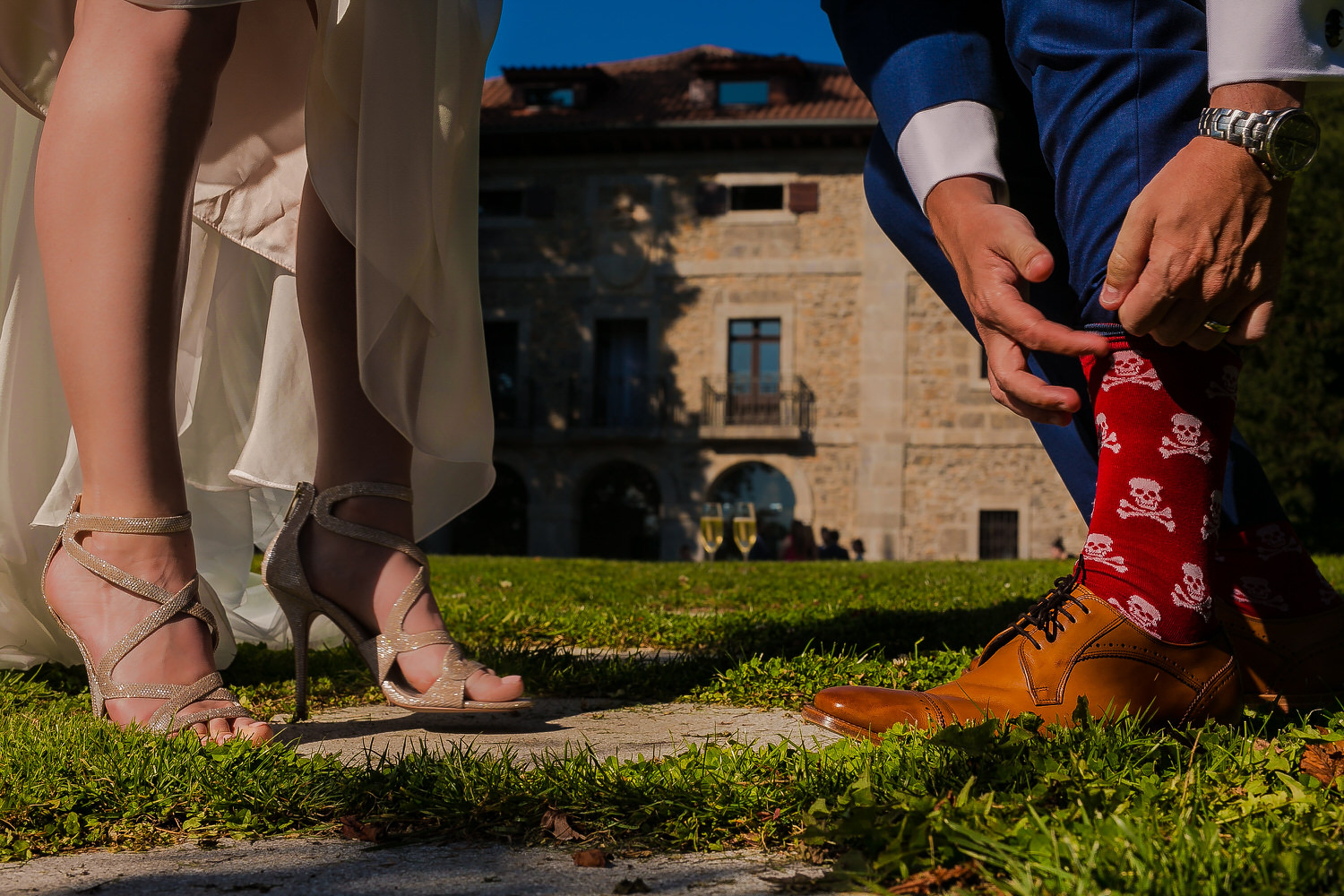 Detalle de los zapatos de los novios frente a un palacio, boda de destino