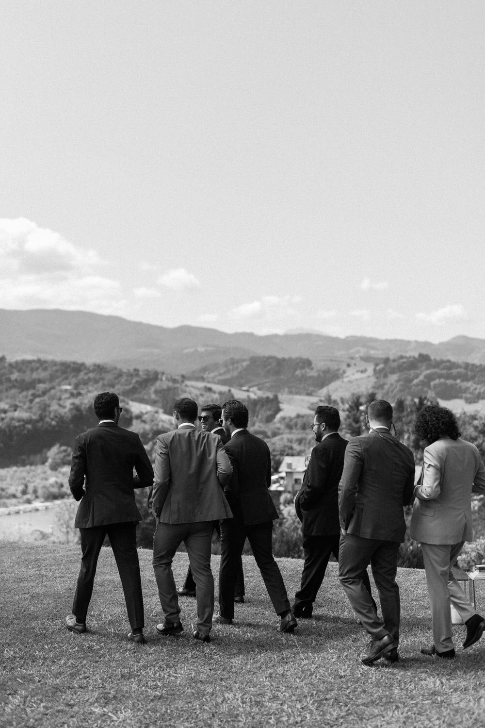 Grupo de padrinos mirando al paisaje de montaña, en blanco y negro
