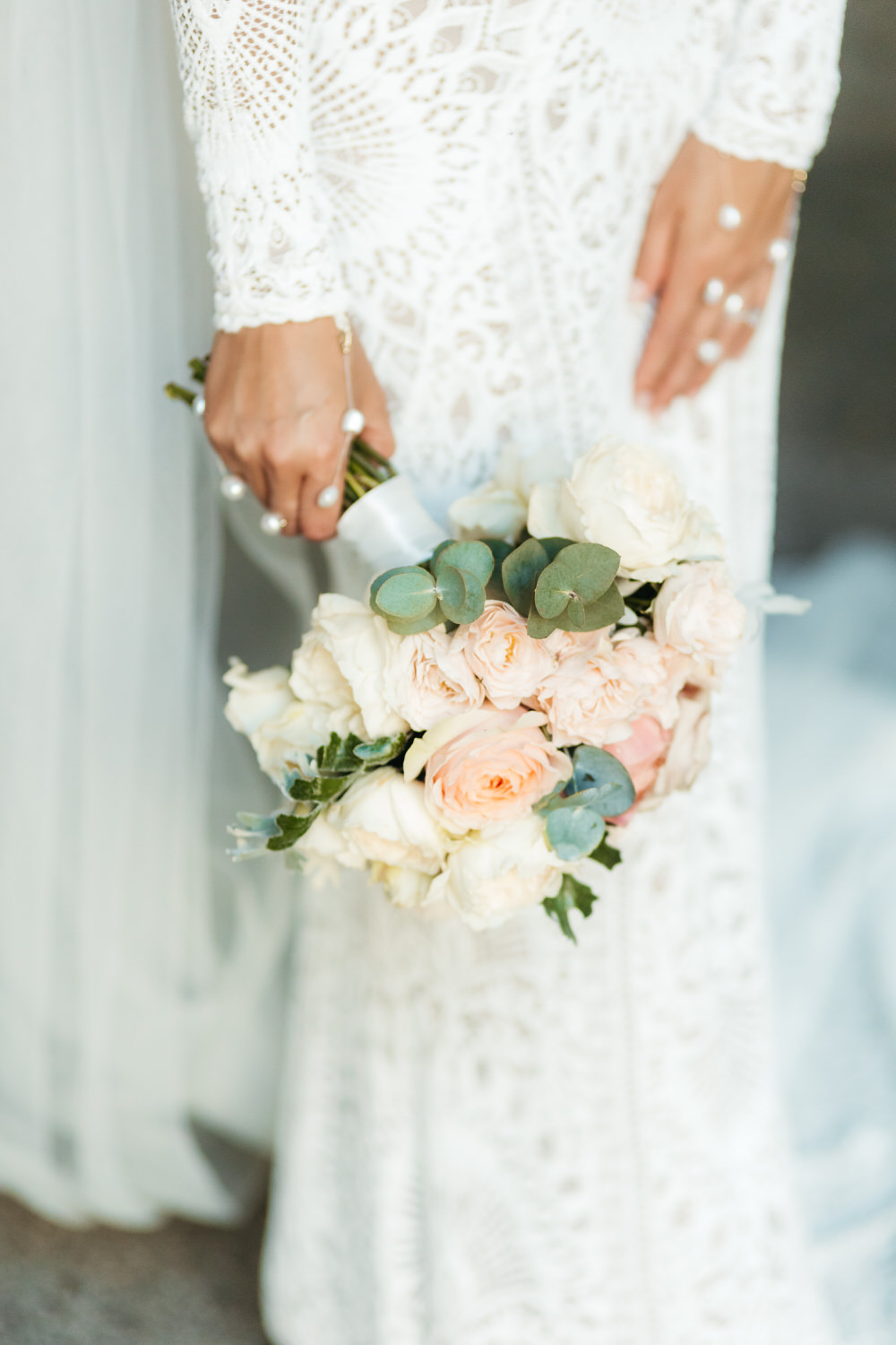 Detalle del ramo de novia sujeto con las manos