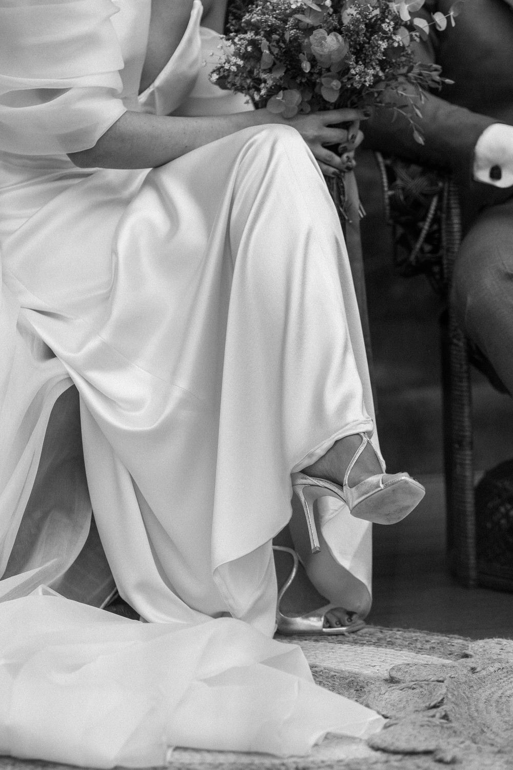 Detalle del vestido y los zapatos de la novia sentada